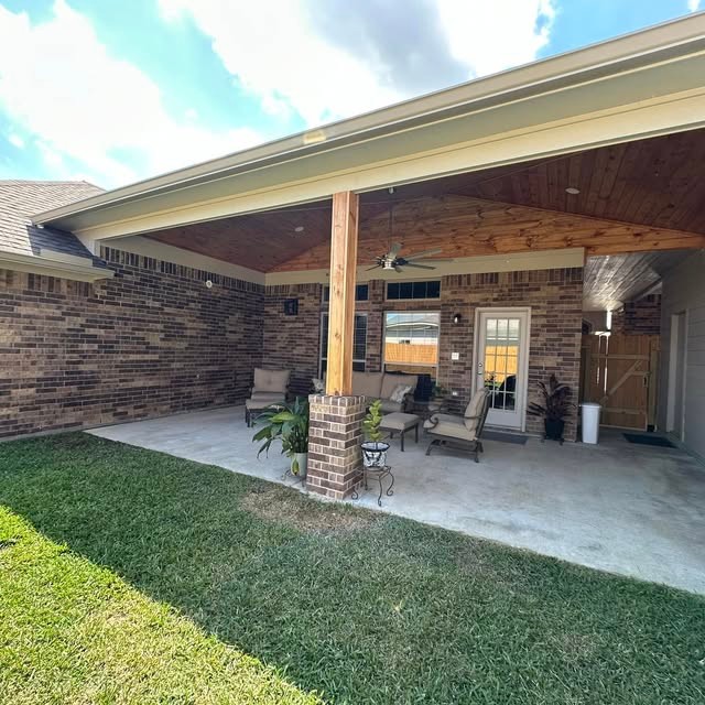 Covered patio with stained tongue-and-groove wood ceiling by Gudino & Sons